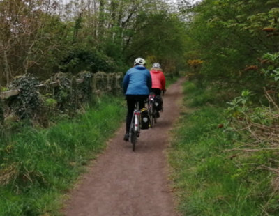 Image of two people cycling along the Trans Pennine Trail Greenall's Avenue path