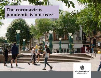 People walking past a fountain in the town centre - The coronavirus is not over