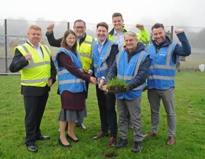Image of staff and members celebrating the start of work on the new 3G pitch at Cardinal Newman High School.