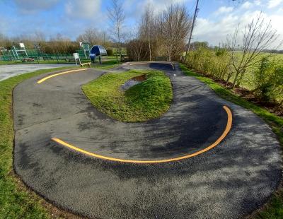 Image of a pump track in a park setting.