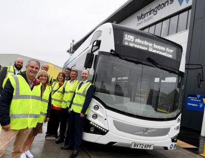 Image of council members, council officers and representatives of Volvo Buses and EO Charging standing in front of a new electric bus outside Warrington's Own Buses' new depot.